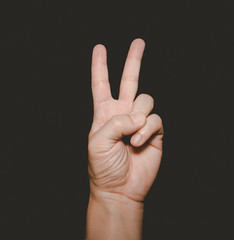 The man's hand that holds two fingers is a V sign, meaning victory. Or still means peace and...