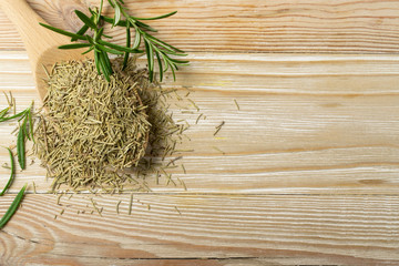 Fototapeta na wymiar Pile of Dry Rosemary on Wooden Background Top View