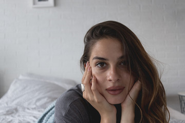 Girl lying in the bed in the morning with natural sunlight entering the room through the window