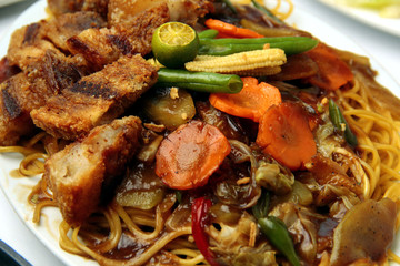 Filipino dish called Pancit Canton topped with Lechon Kawali and mixed vegetables
