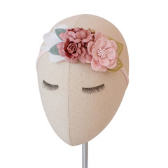 A head mannequin wearing bouquet of flowers made out of fabric cloth textile in beautiful pastel pink theme colors that can be used as hair accessory, decoration, and embellishment