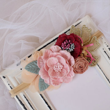 A bouquet of flowers made out of fabric cloth textile in beautiful pastel colors placed on vintage photo frame that can be used as hair accessory, decoration, and embellishment