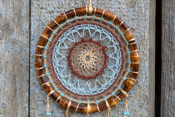 Fototapeta na wymiar Handmade dream catcher with feathers threads and beads rope hanging