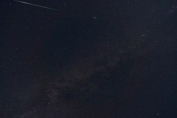 black night sky and stars as background, the milky way and falling Perseid meteors