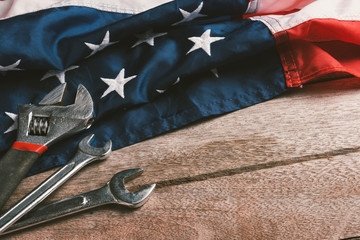 USA Labor day concept, Top view flat lay of different kinds wrenches with American flag on wood table. First Monday in September, creation of labor movement and dedicated to social of American worker