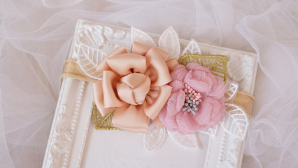 A bouquet of flowers made out of fabric cloth textile in beautiful pastel colors placed on white photo frame that can be used as hair accessory, decoration, and embellishment