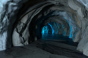 The dark rock tunnel with light illuminated in the end, 3d rendering.