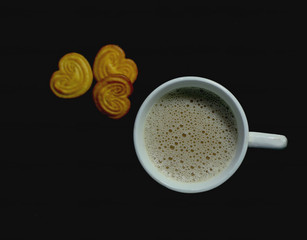 white cup of tea with biscuit love shape 