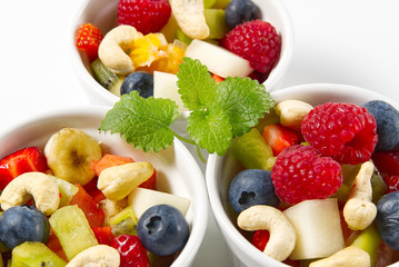 Bowl of healthy fresh fruit salad on white background, top view copy space.