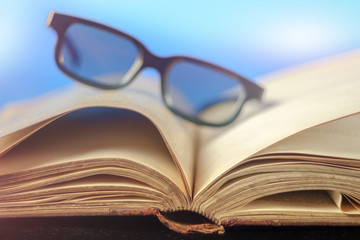 Old vintage opened book with glasses