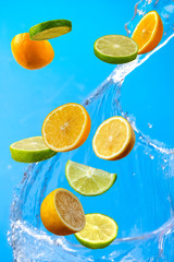 Falling fresh mixed fruits. Slices of the lemon, orange and lime with fresh water in the air