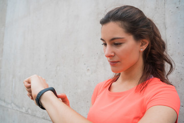 Fitness woman checking time on smart watch.