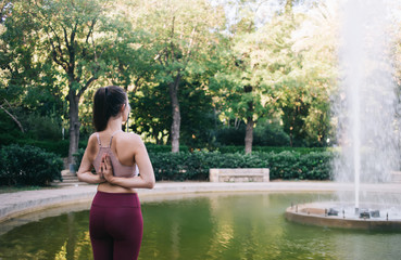 Fit woman practicing calm meditation in park