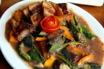 Filipino dish called Pinakbet or mixed vegetables in fish paste sauce with crispy pork belly