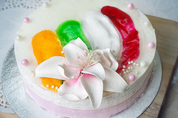 Sponge cake with white cream and a flower on the table, top view.