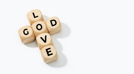 God is Love concept. Wooden blocks forming a cross with text isolated on white background. Copy space