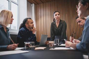Young businesswoman talking with colleagues during a boardroom m
