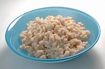 groats in plate on white