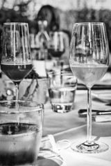 Gläser auf gedecktem Tisch mit Wein, Sekt, Champagner in schwarz weiß, mit Freunden feiern nach...