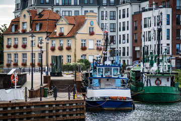 Fototapeta na wymiar Fishing boats tied up at the pier of Motlawa river in the harbor of the historical part of Gdansk, Poland