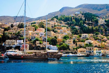 Greece, Symi island, view of Yalos, the port of Symi with sailing boat in the foreground.