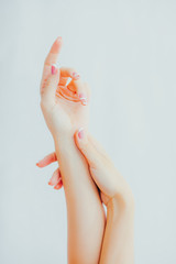 Naklejka premium Female hands with french manicure on gray background