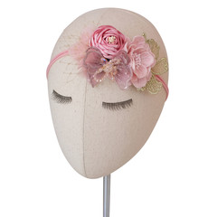 A head mannequin wearing bouquet of flowers made out of fabric cloth textile in beautiful soft pastel pink theme colors that can be used as hair accessory, decoration, and embellishment