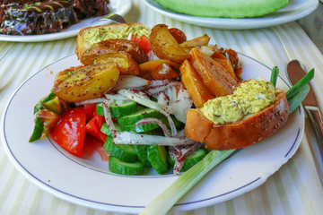 Mediterranean breakfast plate with vegetables, bread and baked potatoes