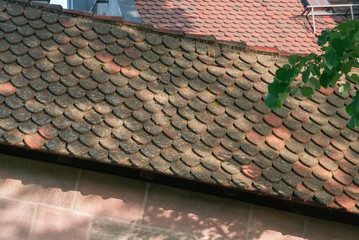 Abstract architectural background with fragments of old tiled mossy roofs