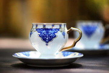 two turkish coffee cups on wooden table with blurred warm background