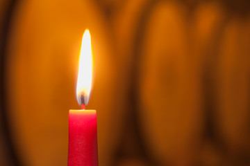 Close-up of a burning red candle in a wine cellar
