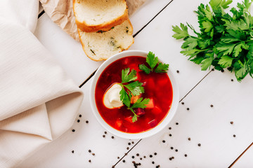 Borscht with fresh bread on a natural wooden background. Red beetroot soup with fresh bread