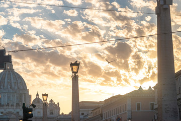 View of the cathedral in the Vatican Rome Italy of San Pietro against the golden sunset sky