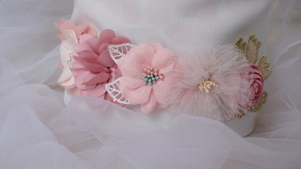 Handmade flower made out of fabric cloth textile in beautiful soft pastel pink theme colors that can be used as hair accessory, decoration, and embellishment