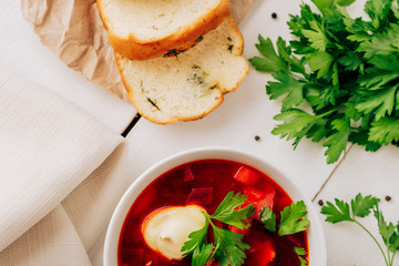 Borscht with fresh bread on a natural wooden background. Red beetroot soup with fresh bread