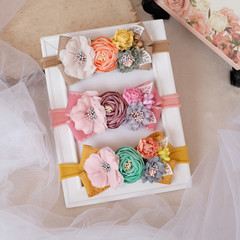 Handmade flower made out of fabric cloth textile in beautiful soft pastel colors placed on white photo frame that can be used as hair accessory, decoration, and embellishment