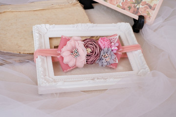Handmade flower made out of fabric cloth textile in beautiful soft pastel pink theme colors that can be used as hair accessory, decoration, and embellishment placed on white photo frame