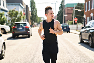 portrait of an athletic young man running and working out in the city