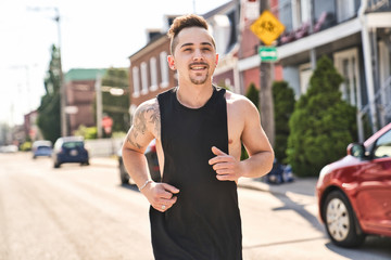 portrait of an athletic young man running and working out in the city