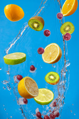Slices of the lemon, orange, lime, kiwi and cherry with fresh water in the air