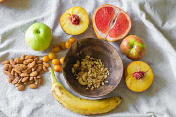 
Making a vegan smoothie bowl with peach, banana, chia, granola and almonds in a coconut bowl. Vegan breakfast.  Almond heart