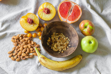 
Making a vegan smoothie bowl with peach, banana, chia, granola and almonds in a coconut bowl. Vegan breakfast.  Almond heart