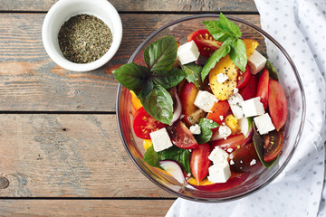 Salad with tomatoes, peach, red onion, feta cheese and basil.