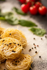 close up view of raw Italian Capellini with flour and black pepper
