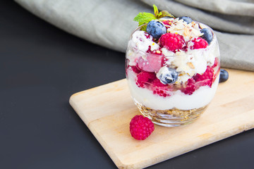 Healthy blueberry, raspberry and walnut parfait in a glass on a white background