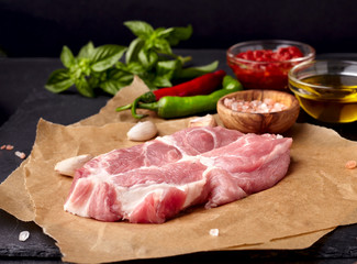 Meat on the black stone with   basil, tomato sauce, olive oil, pepper and garlic.  Meat steak with spices.