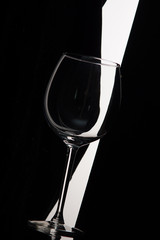 Empty wine glass bent over black and white background