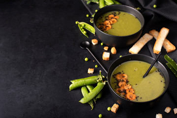 green pea and carrot puree soup in black bowls
