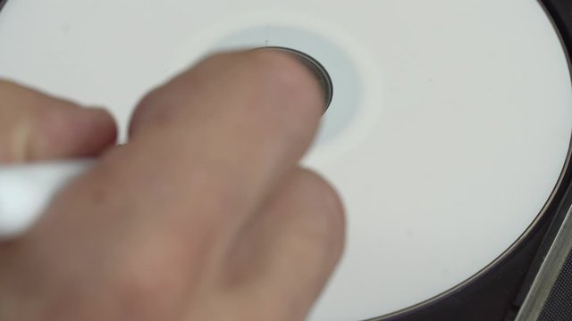 a human hand writes data on a white CD. Marker. Marks that important information is saved on this disk.