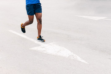 unrecognizable man running on the asphalt